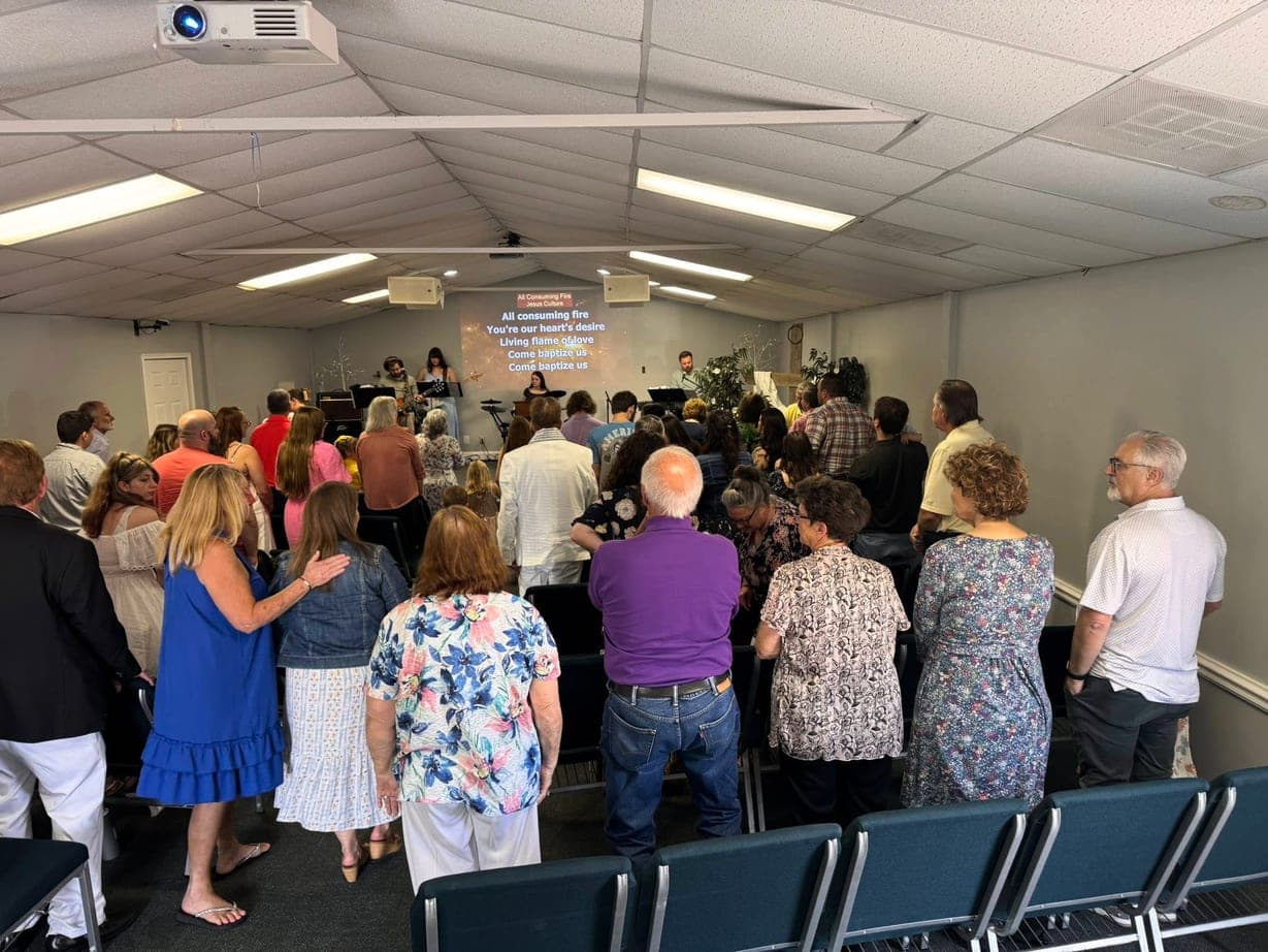 The New Vision Outreach congregation standing together during worship